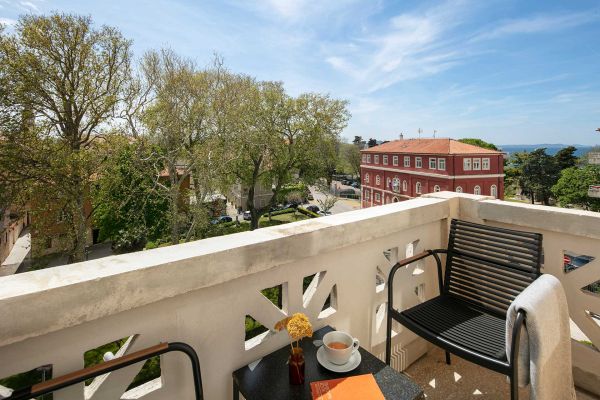 Captivating panoramic views of the lush park, gleaming sea, and Zadar's enchanting Old Town from the balcony of Deluxe Double Room 'Gjika' at Almayer Art & Heritage Hotel's annexe building