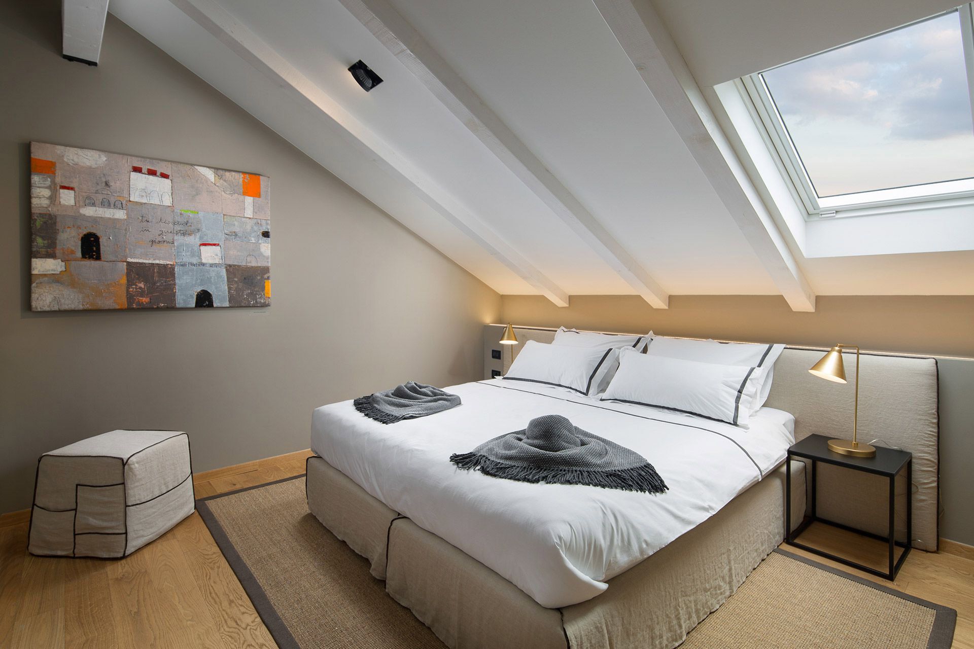 Cosy mezzanine bedroom with a comfy king-size bed and painting in Almayer hotel’s deluxe double room